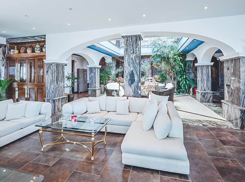 Living room with white sofas, archways, marble columns and greenery at Villa Jorden, Sa Carroca, Ibiza