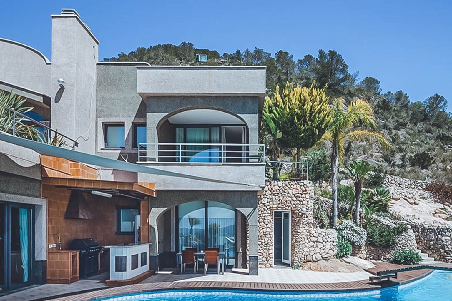 Exterior, modern villa with pool and olive tree landscape at Villa Jorden, a luxury villa in Sa Carroca, Ibiza