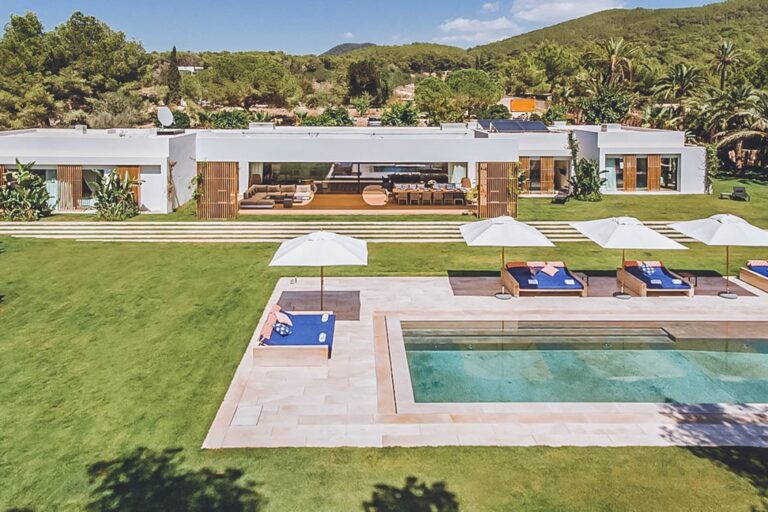 Villa Moriah, San Jose, Ibiza: exterior white villa with pool green lawn loungers and mountain views
