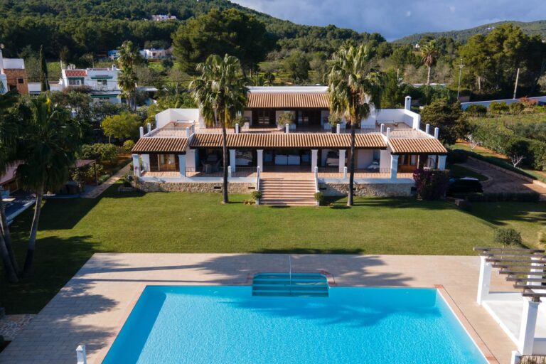 Exterior, villa with wood pergolas, turquoise pool, palm trees, hills at Finca August in Santa Eulalia del Rio, Ibiza