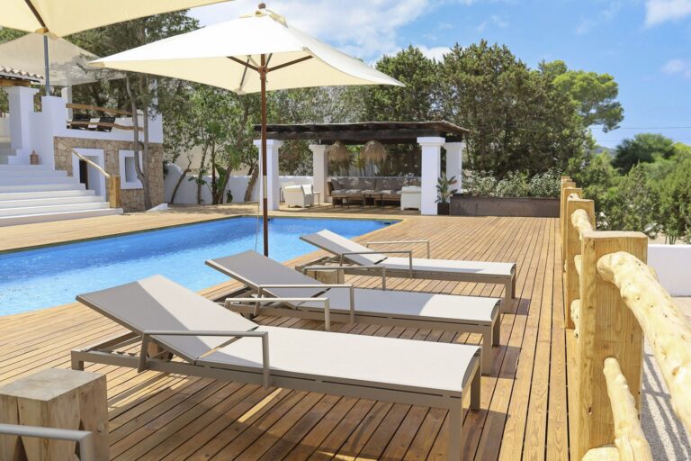 Pool terrace with wooden decking, umbrellas and pergola at Casa Rafael, luxury villa rental in San Josep, Ibiza