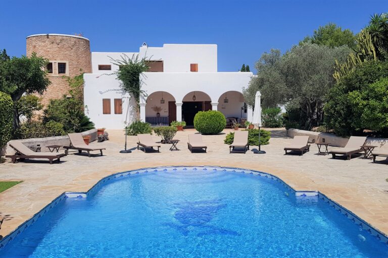 Exterior, white villa with stone tower and pool terrace at Carrion Estate, San Juan, Ibiza
