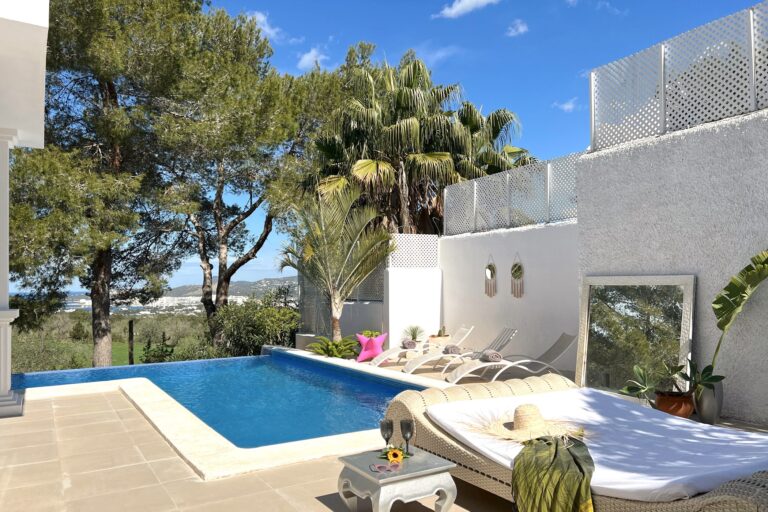 Pool terrace with loungers, umbrellas and landscaping at Casa Buena, San Antonio, Ibiza