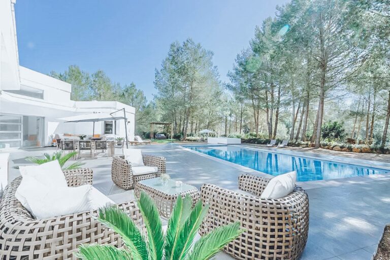 Terrace, modern building with wicker seating at dusk with ambient lighting at Casa Ivan, a luxury villa in Santa Eulalia del Rio, Ibiza