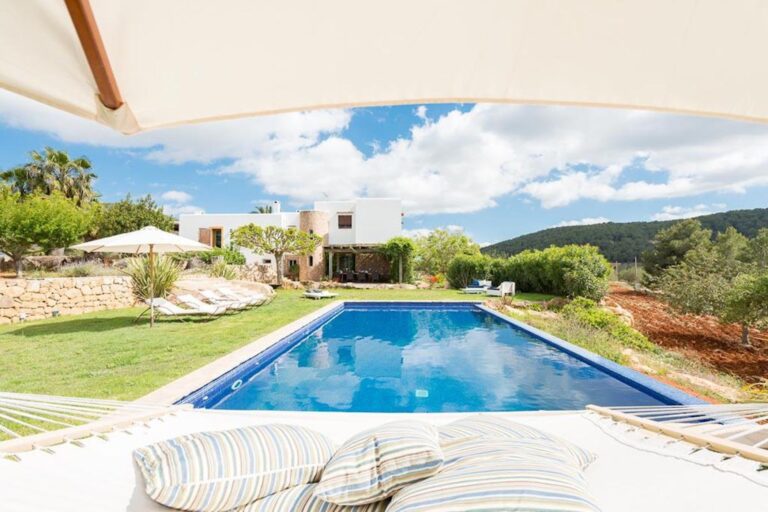 Aerial view, modern villa with pool surrounded by green countryside landscape at Casa Kai in San Antonio, Ibiza