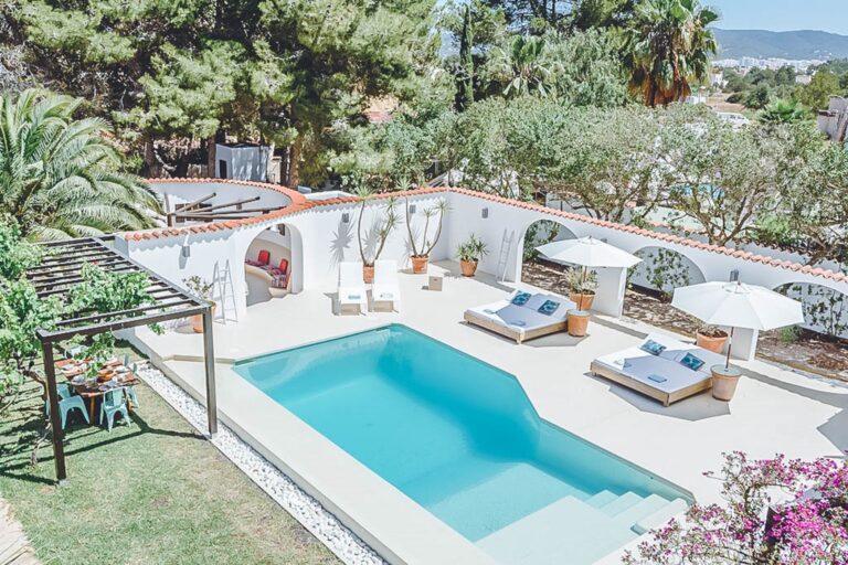 Pool, rectangular with sunloungers and terrace surrounded by trees at Casa Sandria, San Antonio, Ibiza