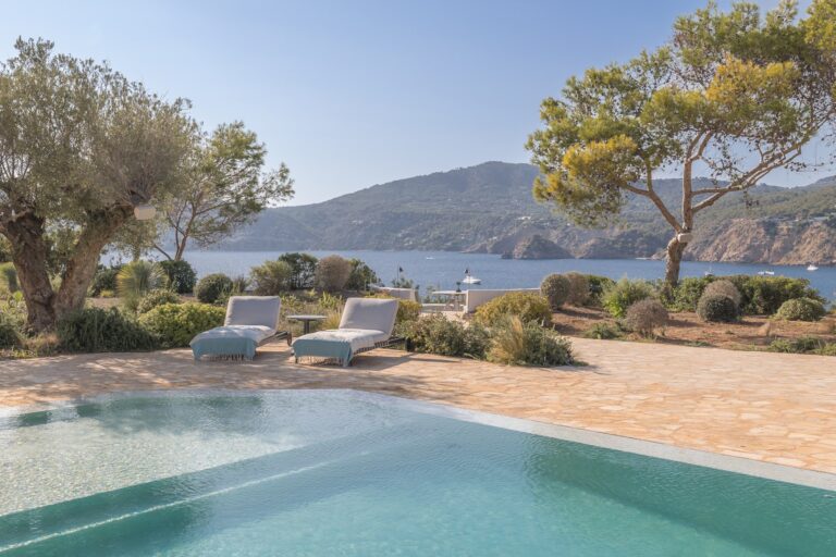 Pool with sea view olive trees loungers and distant water at Dream Waterside, holiday villa in San Josep, Ibiza