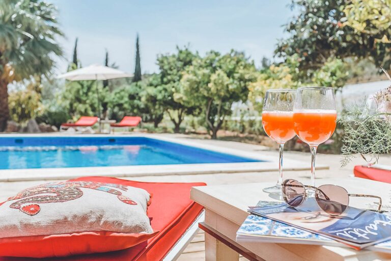 Dining room, stone walls with wooden table and setting at Reina Vista, villa to rent in Santa Eulalia del Rio, Ibiza