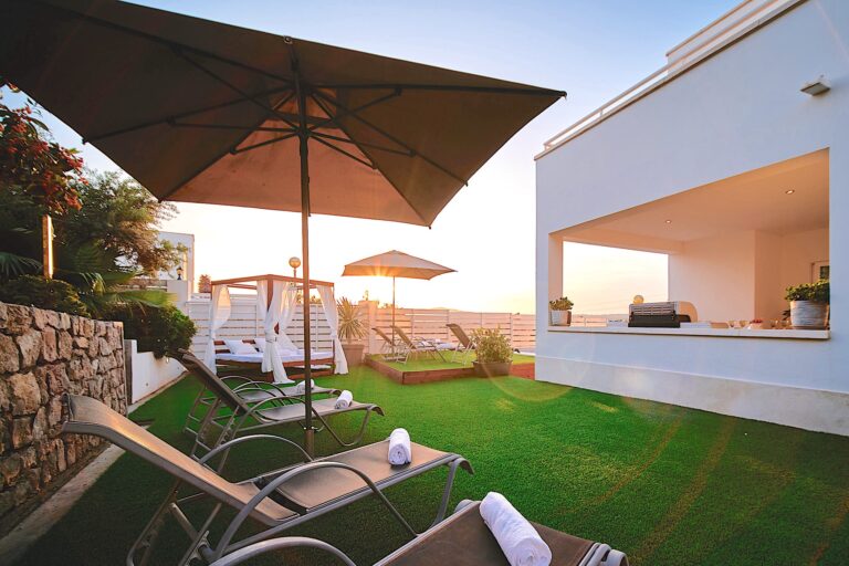 Samy House, Cap Martinet, Ibiza: garden terrace with umbrellas, lounge chairs and sea view