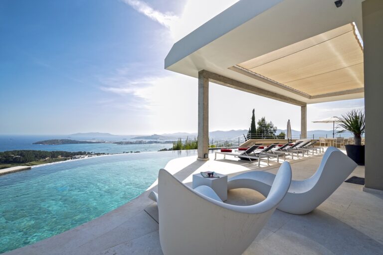 Terrace, infinity pool with white loungers and pergola at Villa Abbie, a luxury villa in Talamanca, Ibiza