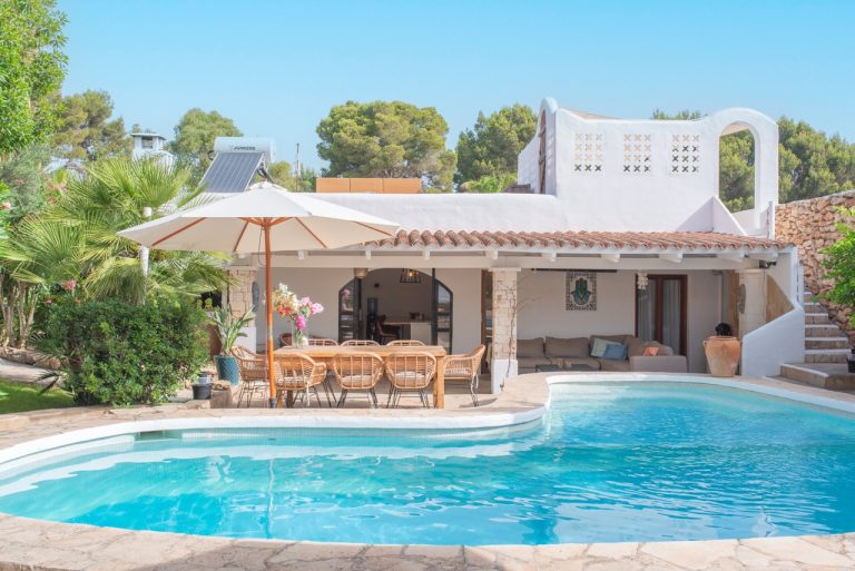 Villa exterior pool with pergola seating and palm trees at Villa Anima, Roca Llisa, Ibiza