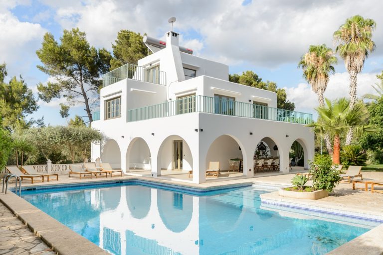 Exterior white modern villa blue infinity pool arched colonnades at Villa Mel in Can Tomas, Ibiza