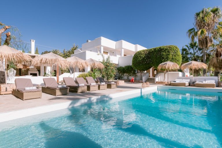 Hanging chair, woven swing seat in garden with cypress trees at Nadal Estate in San Jose, Ibiza