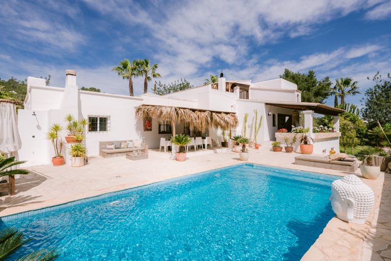 Exterior, white villa with pool and thatched roof at Villa Laris in San Rafael, Ibiza
